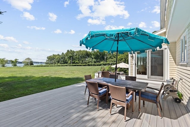 wooden terrace featuring outdoor dining area and a yard