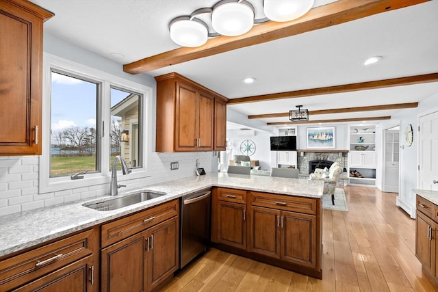 kitchen with beamed ceiling, stainless steel dishwasher, decorative backsplash, and a sink