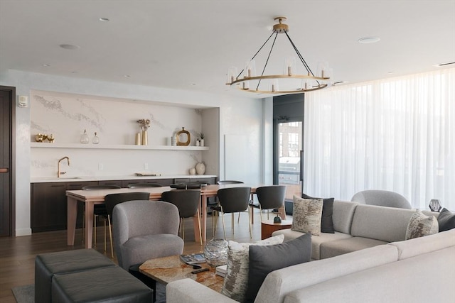 living room with an inviting chandelier, wood-type flooring, and sink