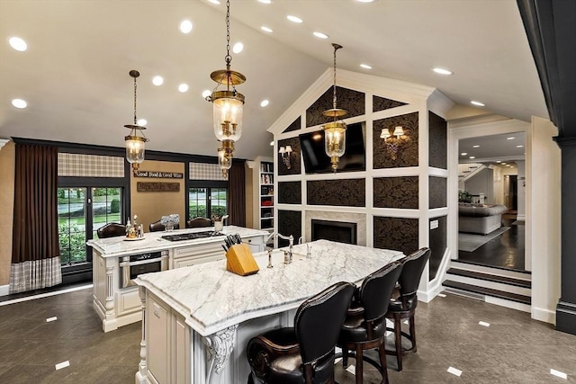 18 Connors Way, Leominster, MA 01453 - kitchen with a large island, stainless steel oven, vaulted ceiling, light stone countertops, and hanging light fixtures