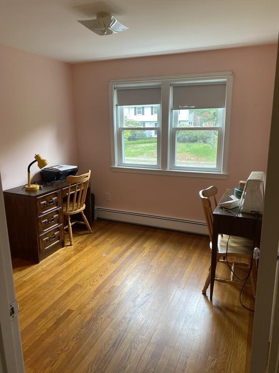 home office with baseboard heating and light wood finished floors