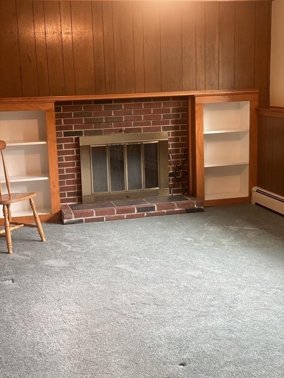 unfurnished living room featuring carpet, wooden walls, a brick fireplace, and a baseboard radiator