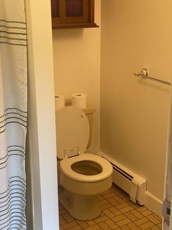 full bath with toilet and a baseboard heating unit