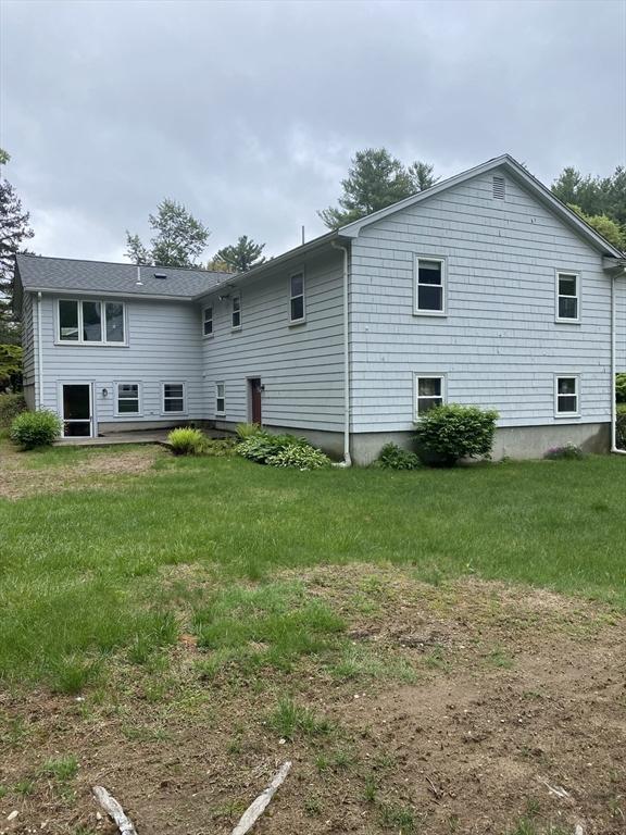 back of property featuring a lawn