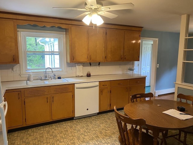 kitchen with dishwasher, a sink, light countertops, a ceiling fan, and light flooring