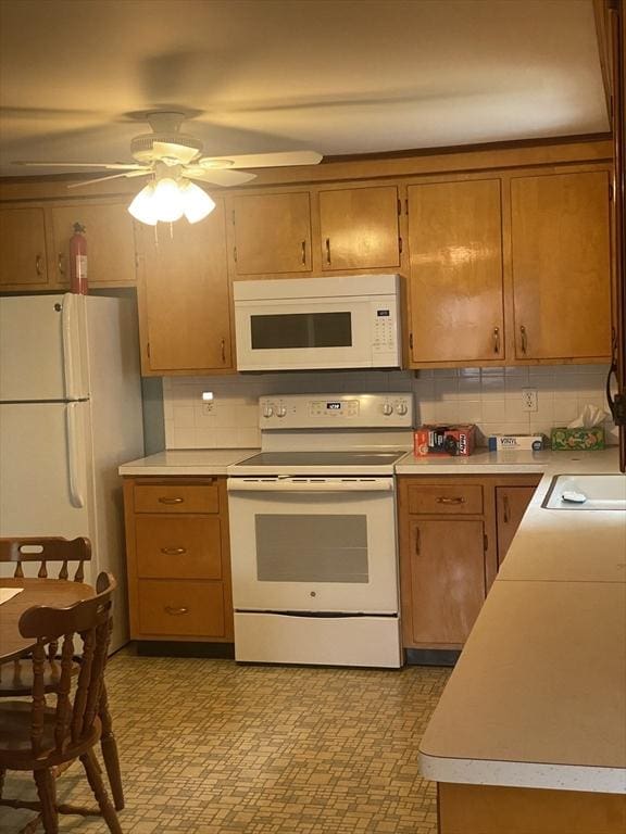 kitchen featuring white appliances, light countertops, ceiling fan, and tasteful backsplash
