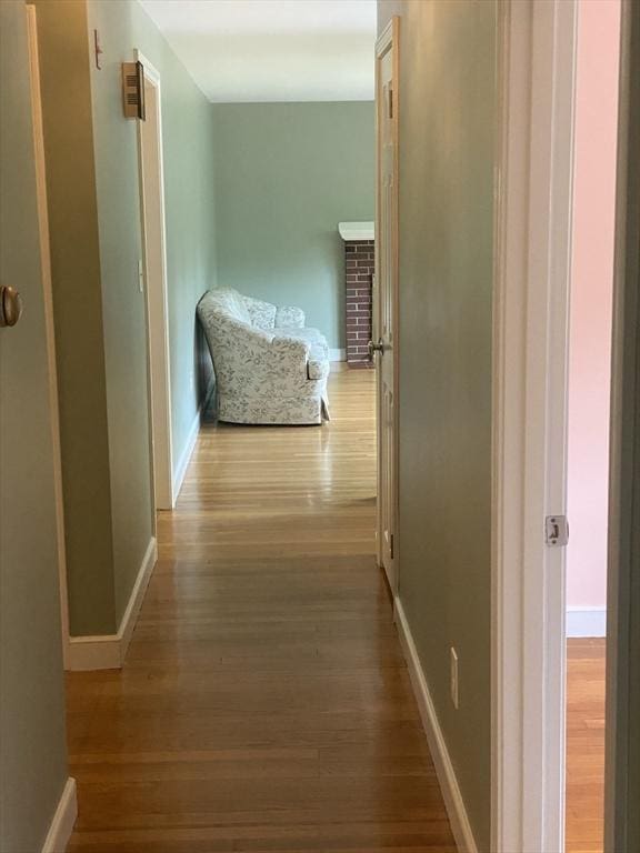 hallway with wood finished floors and baseboards