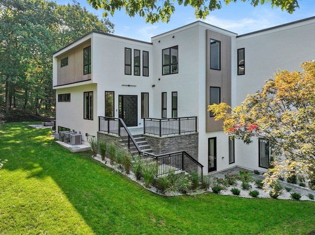 back of property with central air condition unit and a lawn