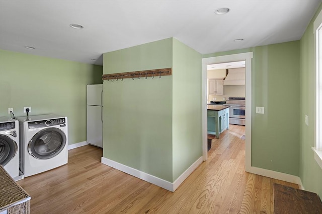 washroom with light hardwood / wood-style flooring and washer and clothes dryer