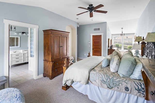 bedroom with ceiling fan with notable chandelier, ensuite bath, light carpet, and vaulted ceiling