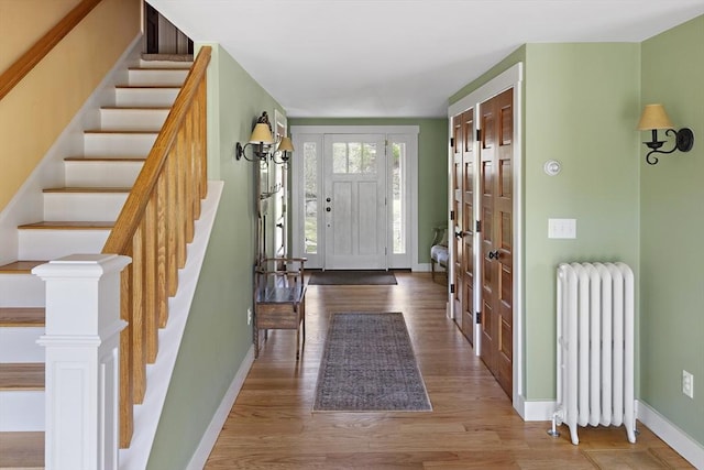 entrance foyer with radiator heating unit and hardwood / wood-style flooring