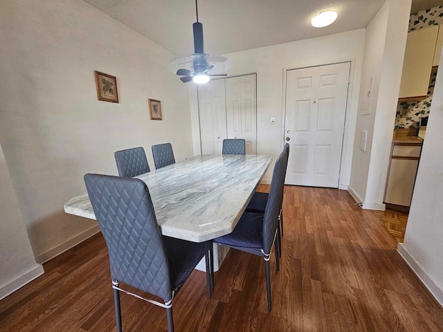 dining space featuring ceiling fan and dark hardwood / wood-style floors