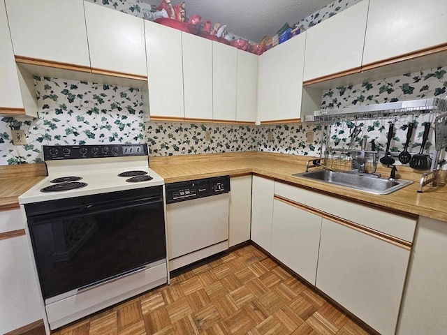 kitchen with white cabinetry, white appliances, backsplash, sink, and light parquet floors