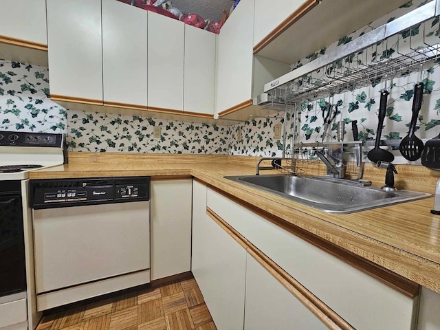 kitchen with white appliances, sink, dark parquet floors, wooden counters, and white cabinets