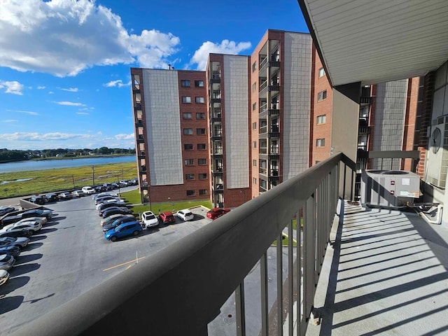 balcony with a water view and central air condition unit