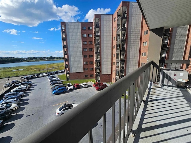 balcony featuring a water view and cooling unit