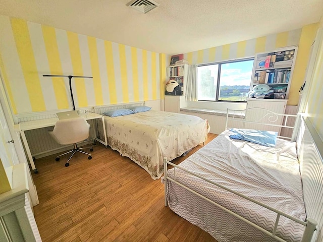 bedroom with wood-type flooring and a textured ceiling