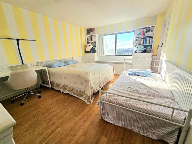 bedroom featuring radiator and hardwood / wood-style floors