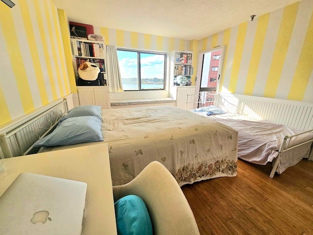 bedroom with hardwood / wood-style flooring and a textured ceiling