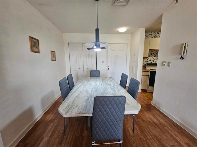 dining room featuring a textured ceiling, ceiling fan, and dark hardwood / wood-style floors