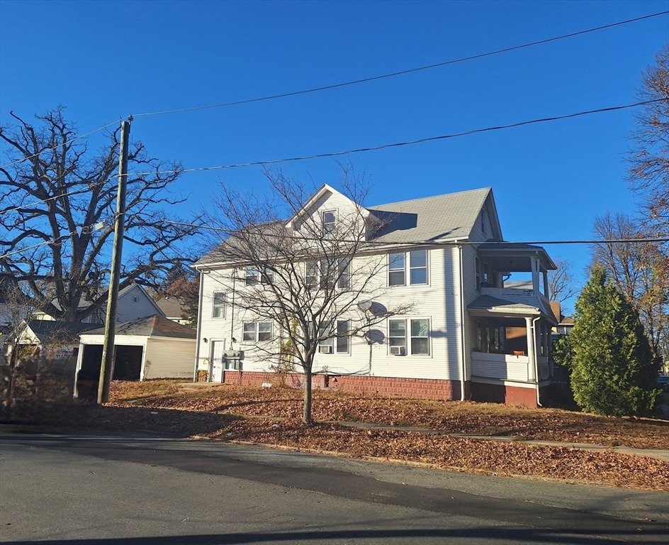 view of front of house with a garage and an outbuilding