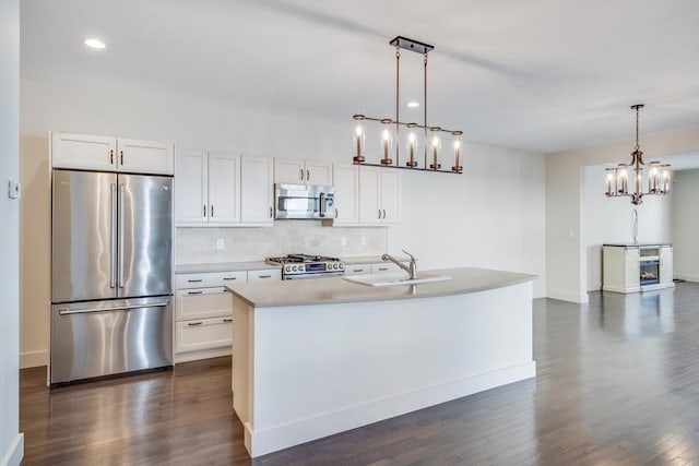 kitchen with white cabinets, backsplash, stainless steel appliances, and a sink