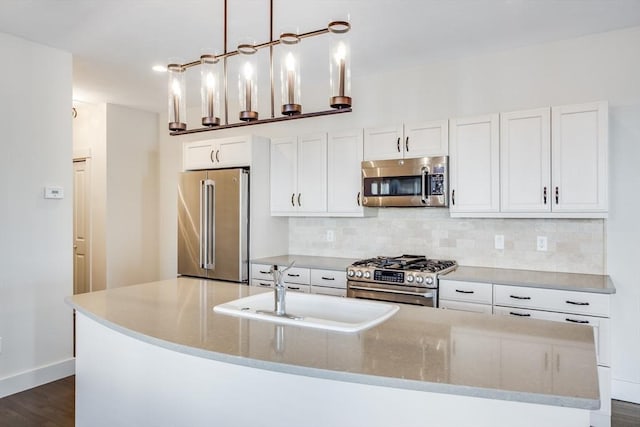 kitchen featuring stainless steel appliances, white cabinets, a sink, and decorative backsplash