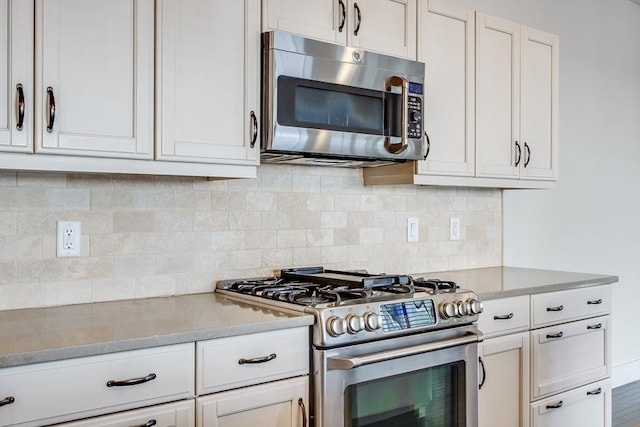 kitchen featuring stainless steel appliances, white cabinetry, and tasteful backsplash