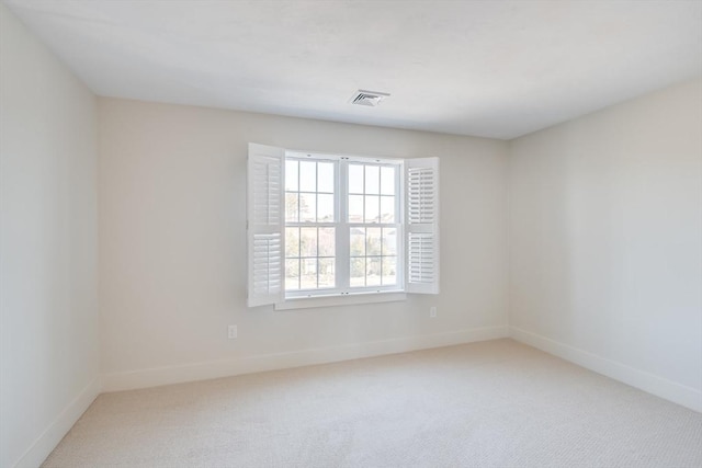 carpeted spare room featuring baseboards