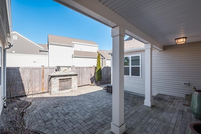 view of patio / terrace with fence and exterior fireplace