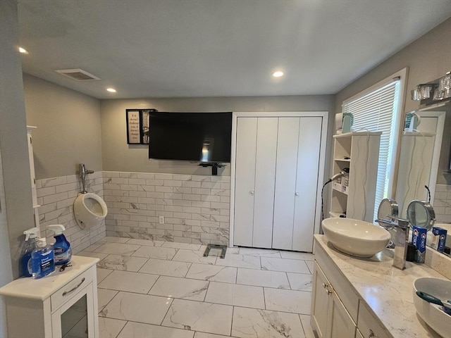 344 Frieda St, New Bedford, MA 02744 - full bath with double vanity, marble finish flooring, tile walls, recessed lighting, and a wainscoted wall