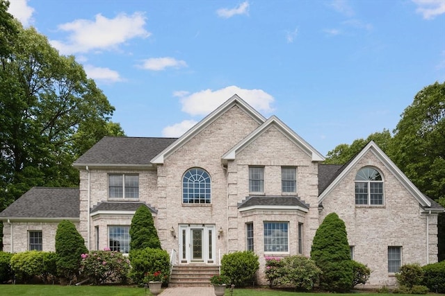 6 Paddock Dr, Lincoln, RI 02865 - traditional home featuring brick siding, a shingled roof, and a front lawn