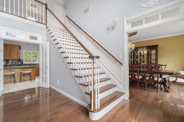 6 Paddock Dr, Lincoln, RI 02865 - stairway featuring wood finished floors, a chandelier, a high ceiling, ornamental molding, and baseboards