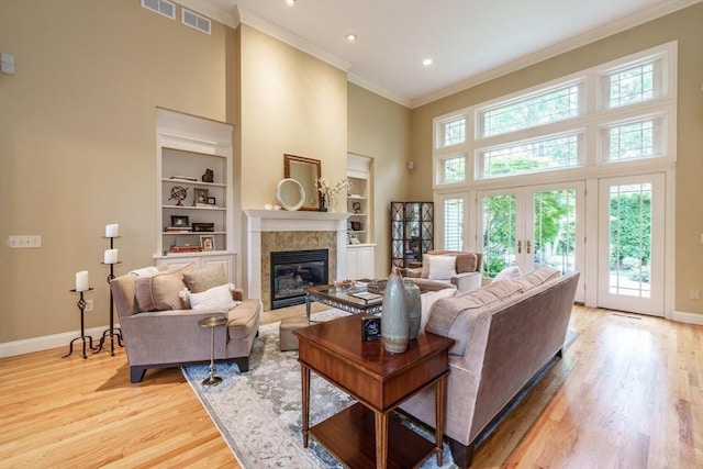 7 Brimfield Way, Westfield, MA 01085 - living area with a high ceiling, baseboards, ornamental molding, a glass covered fireplace, and built in shelves