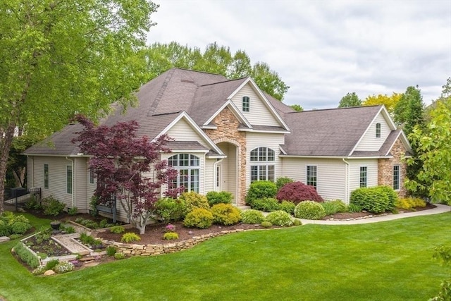 7 Brimfield Way, Westfield, MA 01085 - view of front of house featuring stone siding, a front lawn, and roof with shingles