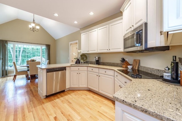 7 Brimfield Way, Westfield, MA 01085 - kitchen with appliances with stainless steel finishes, a peninsula, a chandelier, white cabinets, and vaulted ceiling
