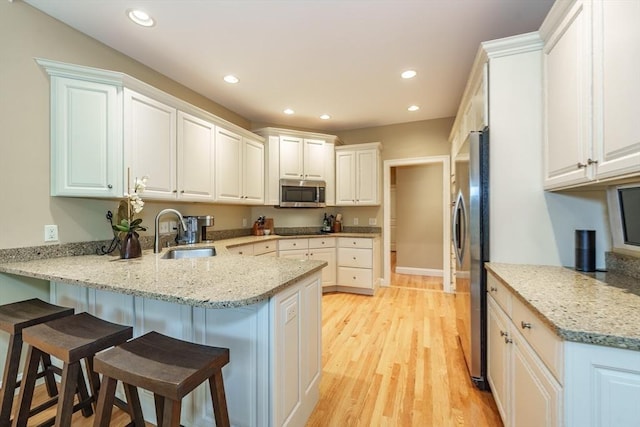 7 Brimfield Way, Westfield, MA 01085 - kitchen featuring a sink, appliances with stainless steel finishes, a peninsula, a breakfast bar, and recessed lighting
