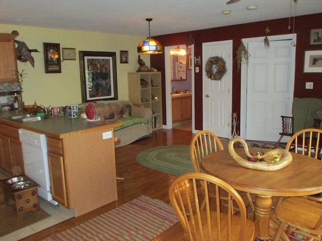 dining space with sink and wood-type flooring