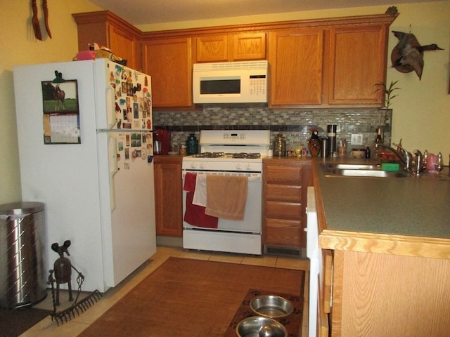 kitchen with backsplash, sink, and white appliances