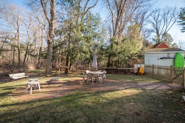 view of yard featuring an outdoor fire pit and a storage shed