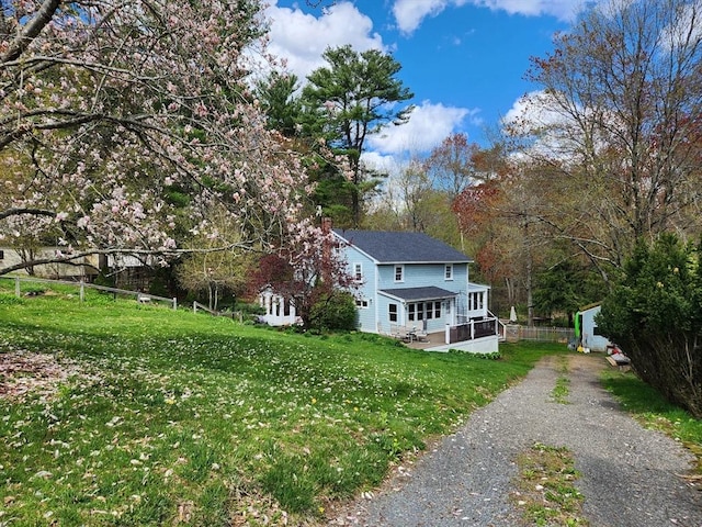 view of front of home featuring a front yard and a wooden deck