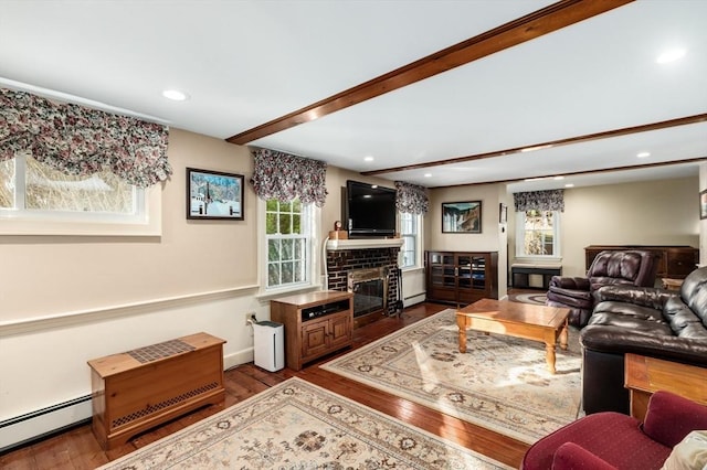 living room with hardwood / wood-style flooring, a fireplace, beamed ceiling, and a baseboard heating unit