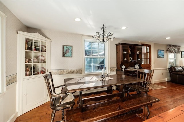 dining area featuring wood-type flooring and an inviting chandelier