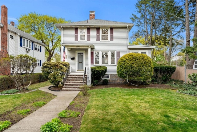 view of front facade with fence, a chimney, and a front yard