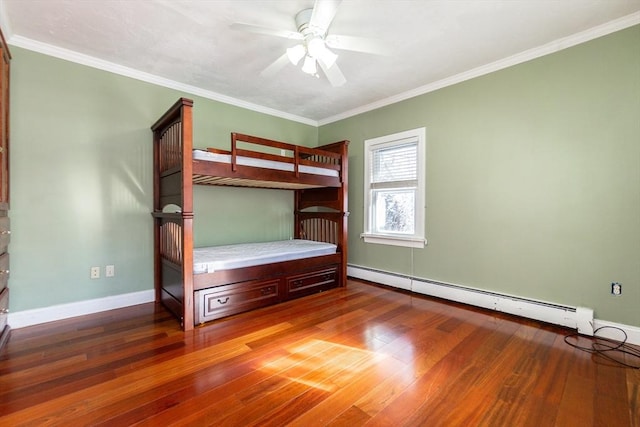 unfurnished bedroom with ceiling fan, a baseboard heating unit, dark hardwood / wood-style flooring, and crown molding