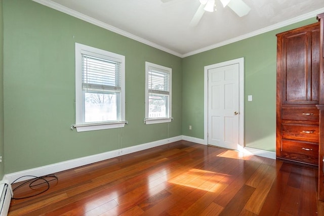 unfurnished bedroom featuring baseboard heating, dark wood-type flooring, ceiling fan, and ornamental molding