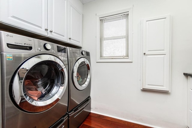 laundry area featuring dark hardwood / wood-style flooring, cabinets, and washer and dryer