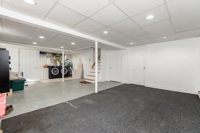 basement with a paneled ceiling and washing machine and clothes dryer