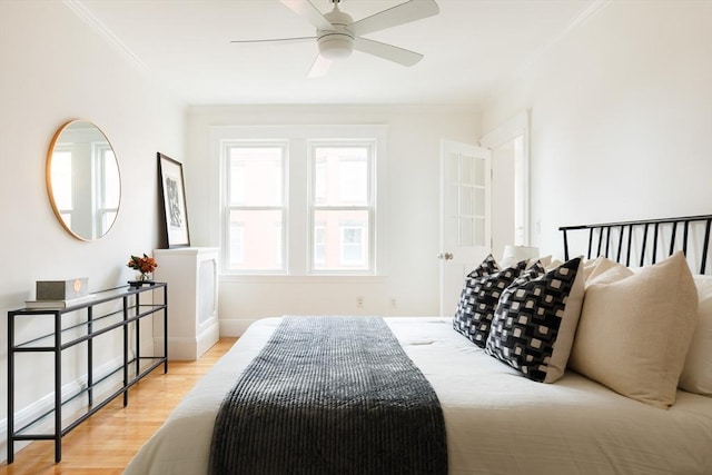 bedroom with baseboards, light wood-style flooring, and ornamental molding