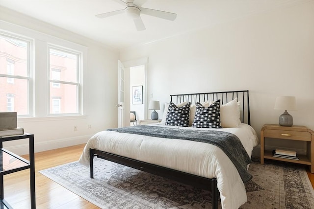 bedroom with ceiling fan, baseboards, and wood finished floors